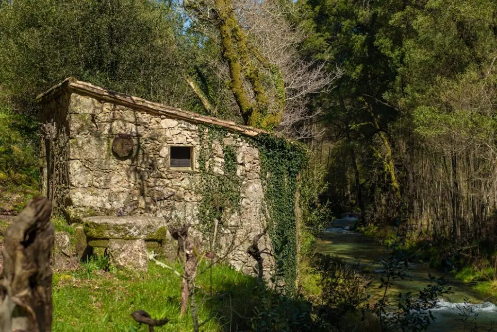 Old stone building near a flowing river.