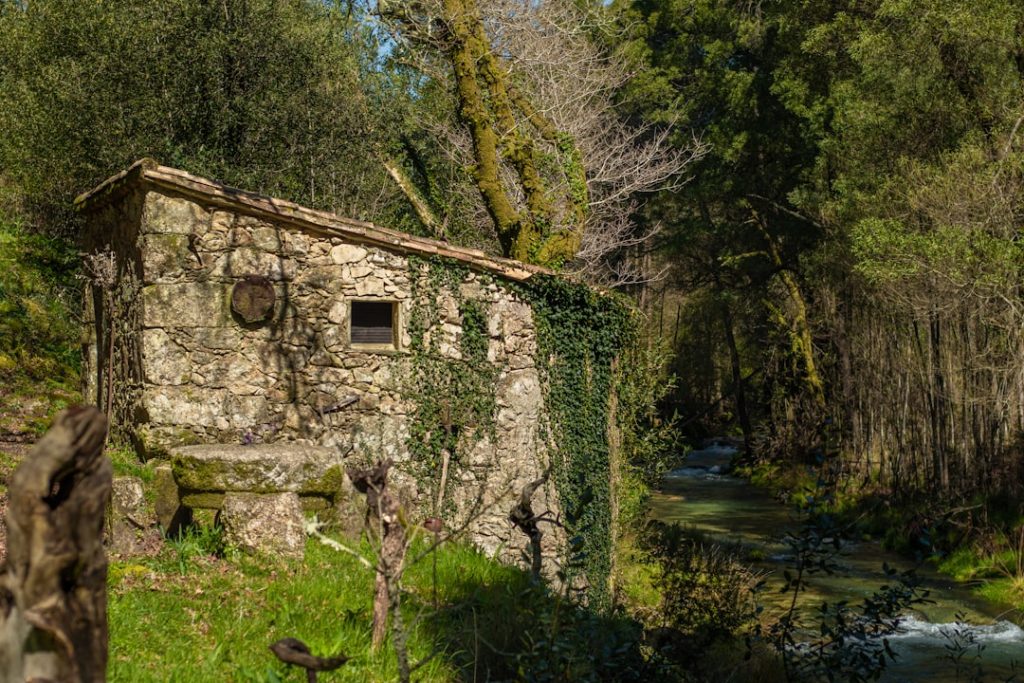 Old stone building near a flowing river.